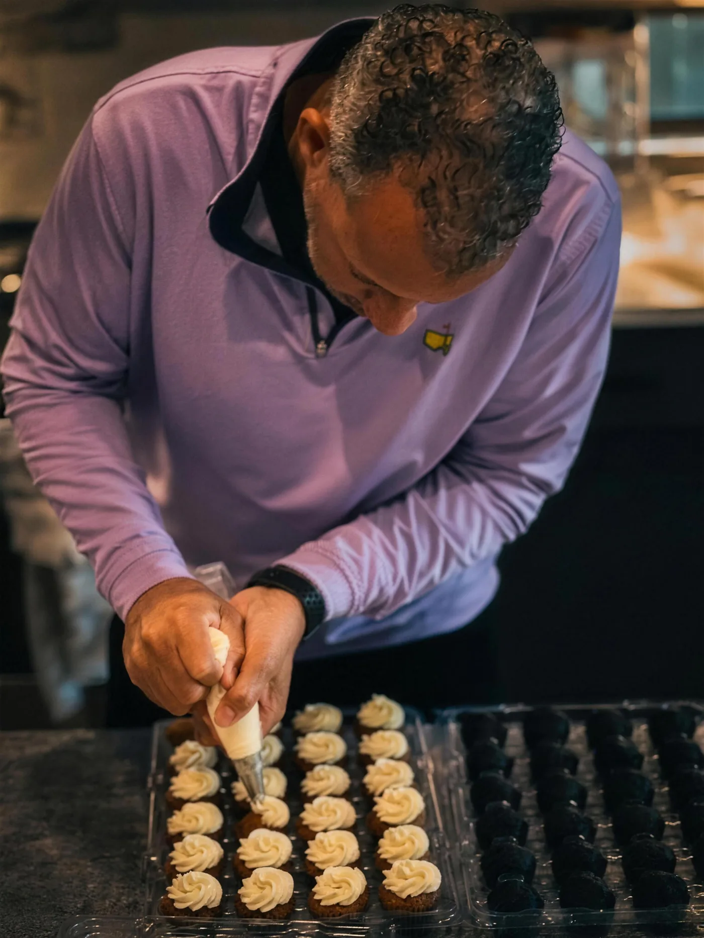 Hand-piping frosting onto fresh cupcakes at Midnite Houston